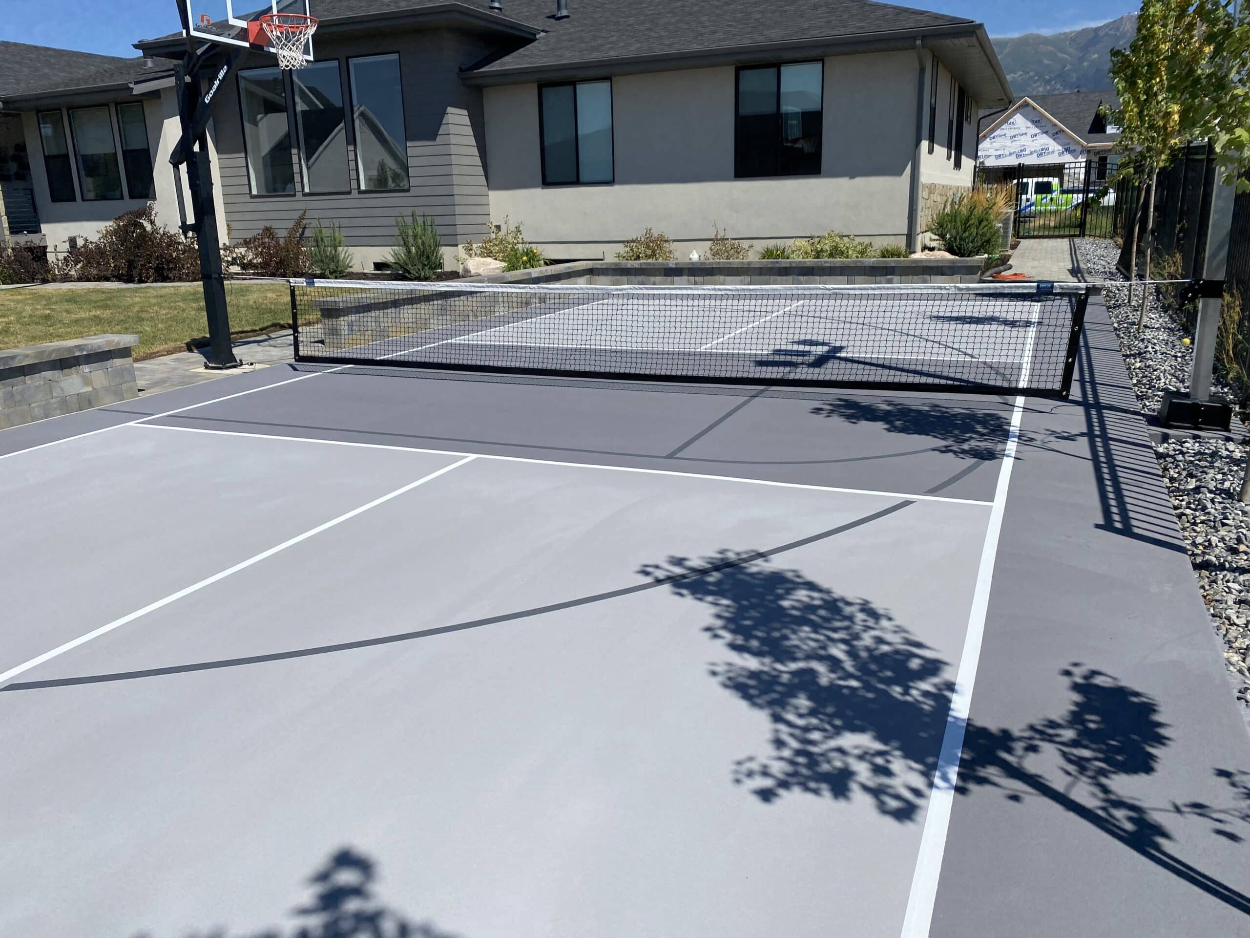 Newly restriped court with clear lines for court markings and a basketball hoop.