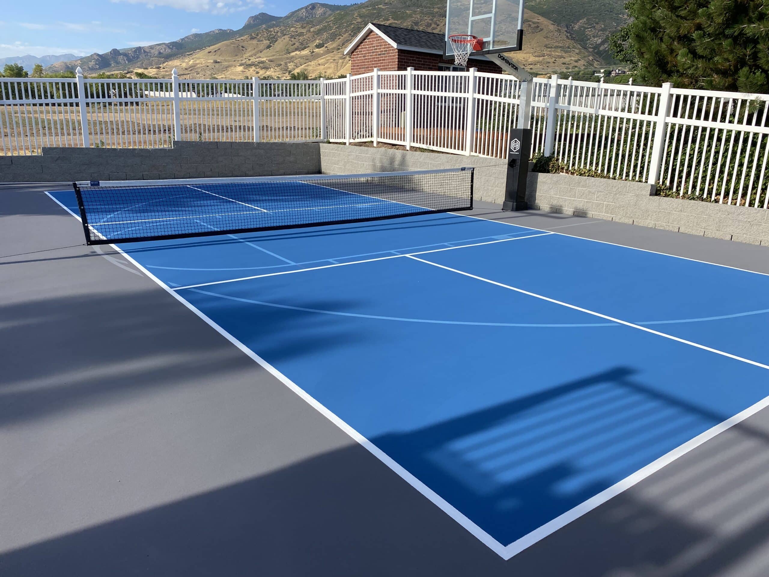 Blue court with clear white lines for court play and a basketball hoop.