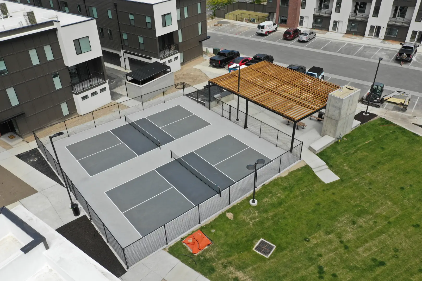 Aerial view of a modern pickleball court with a shaded pergola.
