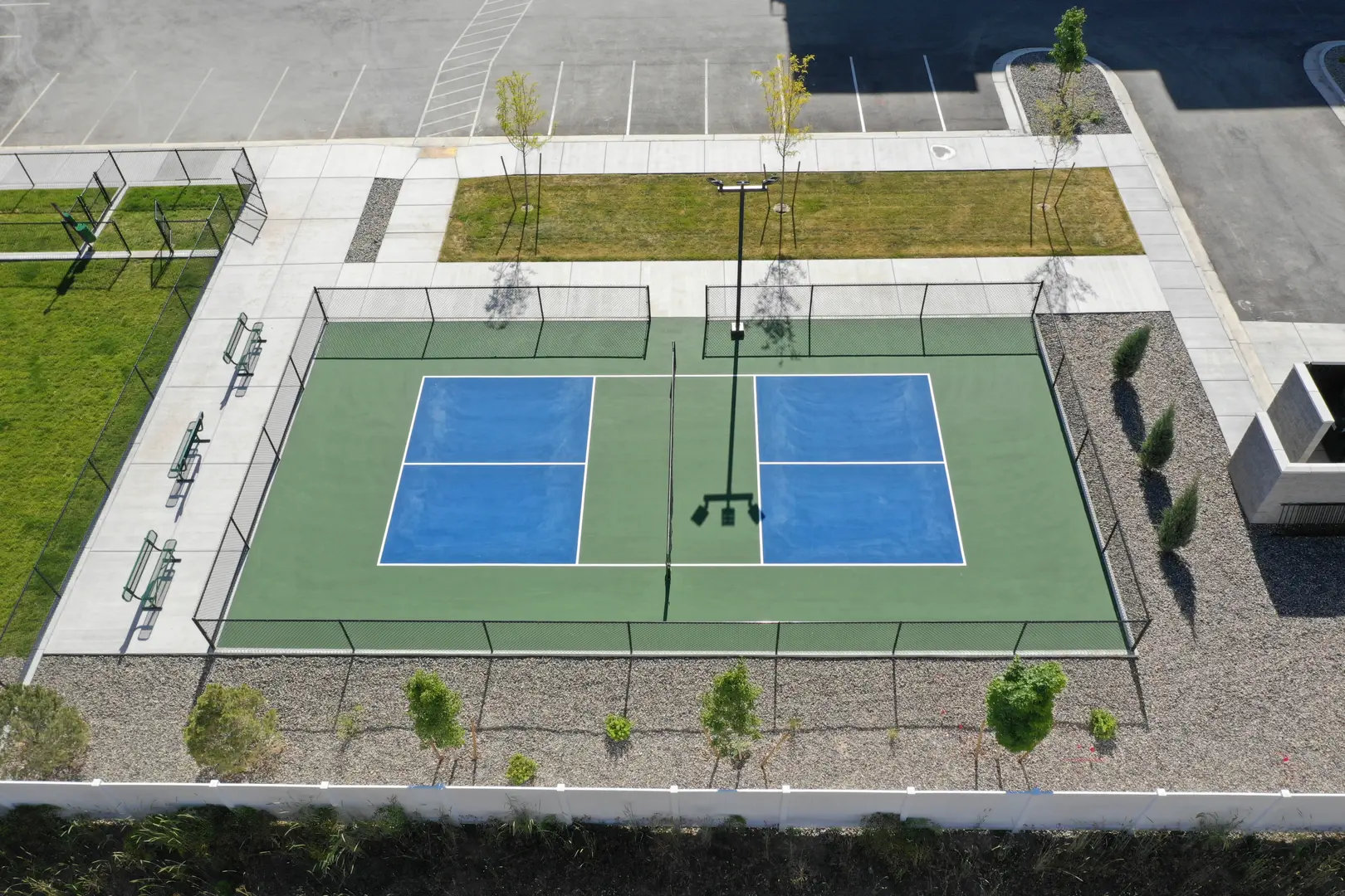 Aerial view of a clean pickleball court with blue playing surfaces.