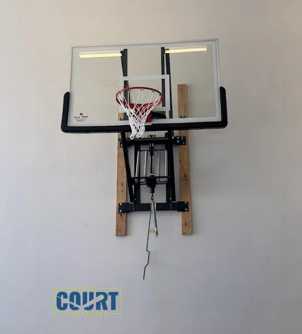 Wall-mounted basketball hoop with clear backboard and red rim.