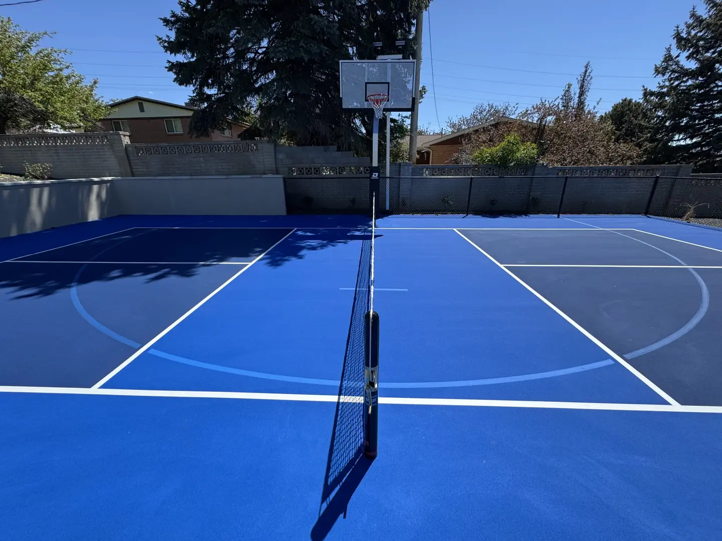 Vibrant blue multi-sport court with basketball hoop and net