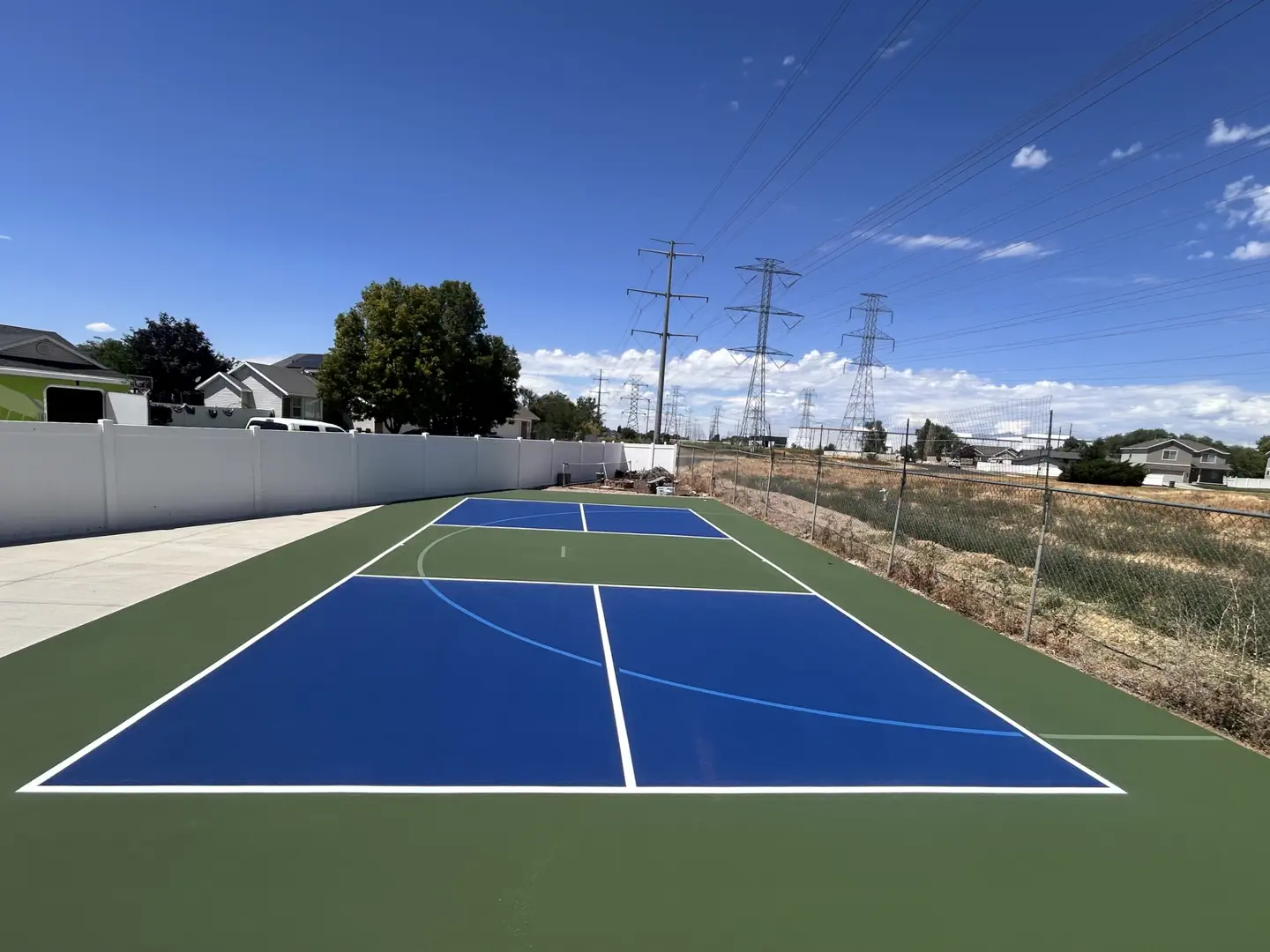 Newly painted blue and green pickleball court with white lines.