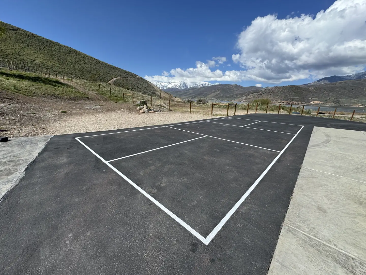 Newly painted pickleball court with mountain and lake views.