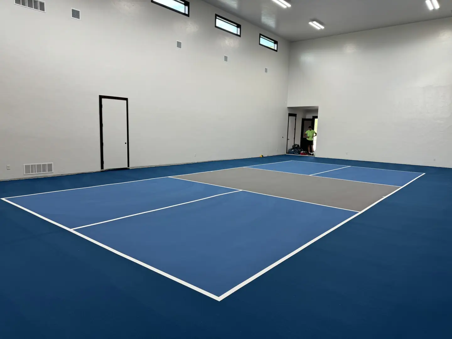 Indoor pickleball court with blue and grey playing surface
