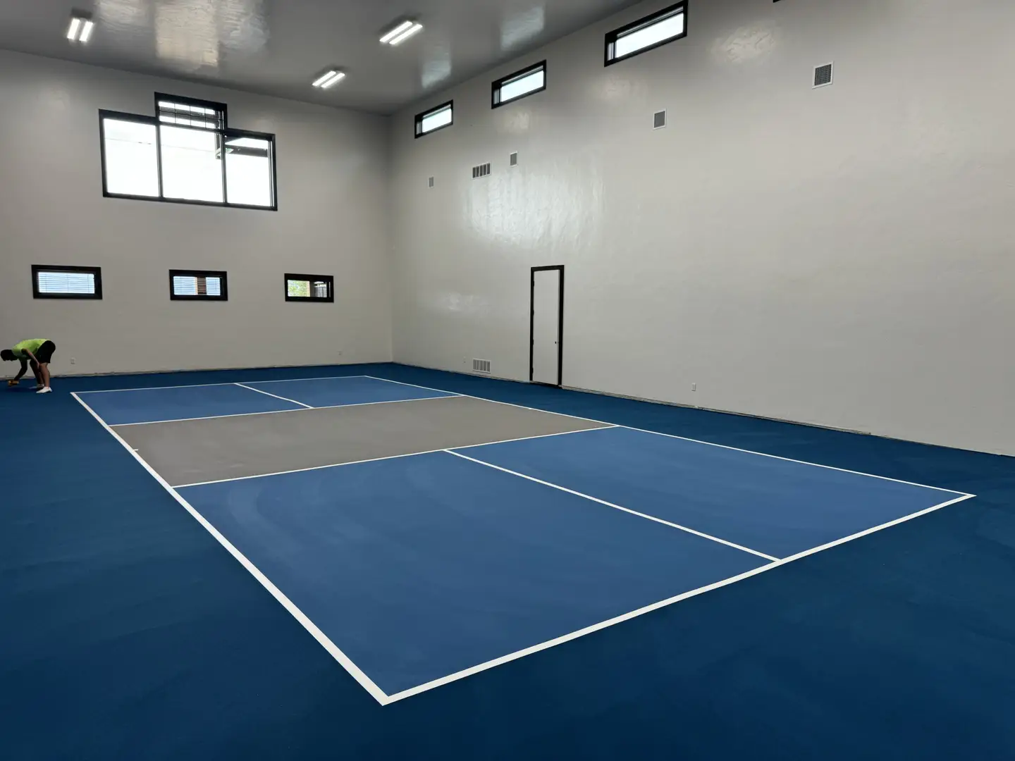 Indoor pickleball court with blue and gray surface