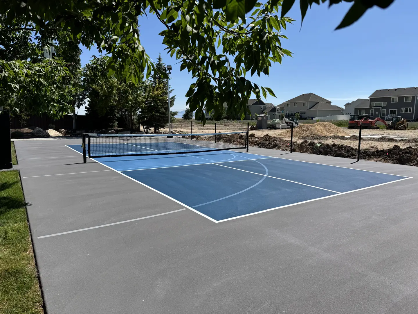 Newly constructed blue pickleball court with gray surrounding area.