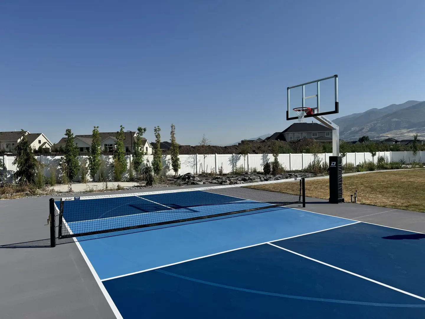 Multi-sport court with basketball hoop and pickleball net