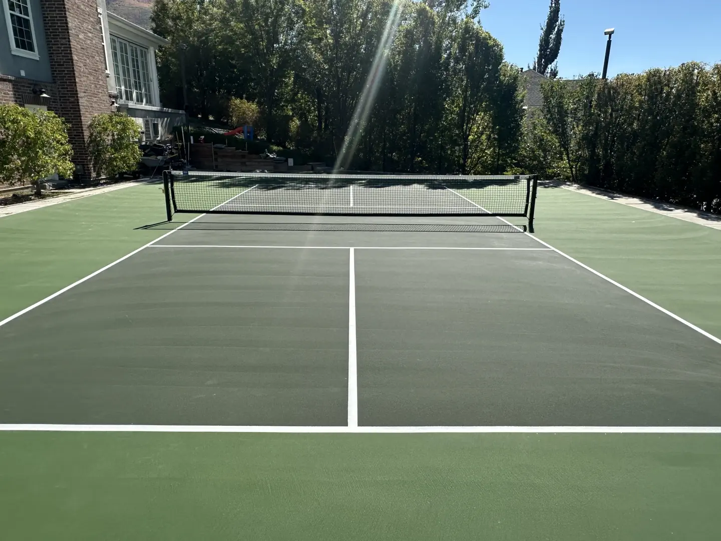 Newly resurfaced pickleball court with green surface and white lines.
