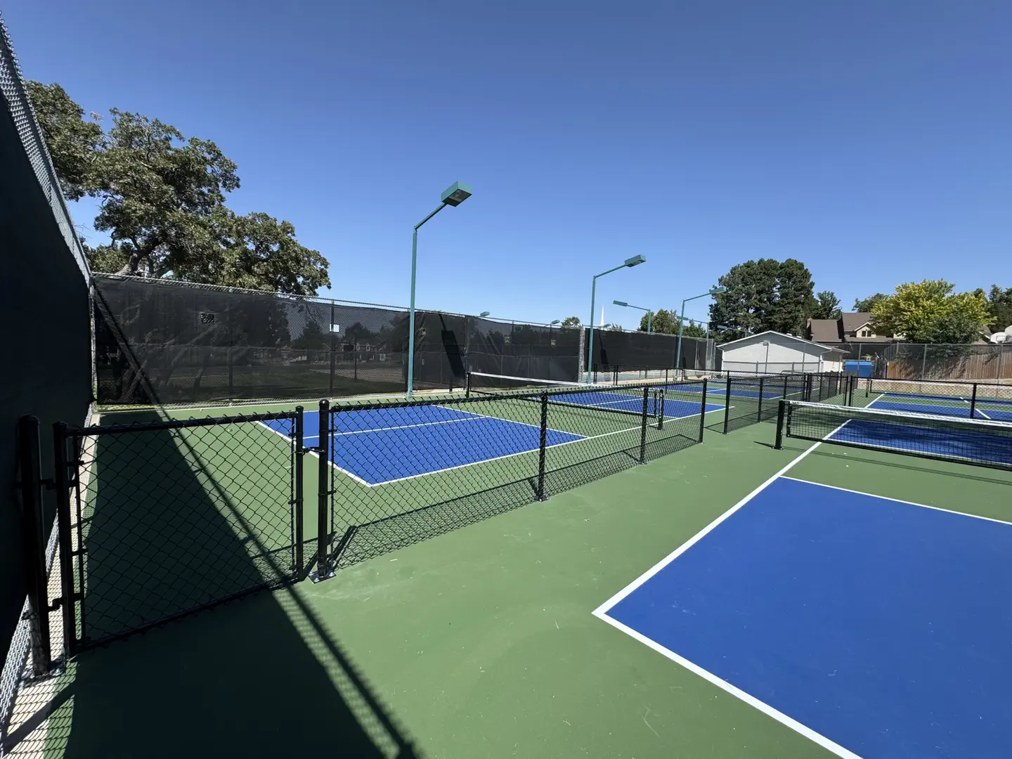 Outdoor pickleball courts with blue and green surfaces.