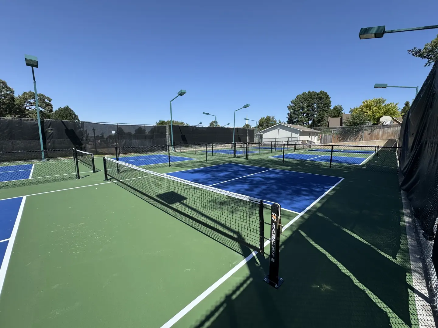 Outdoor pickleball courts with blue and green surfaces and nets.