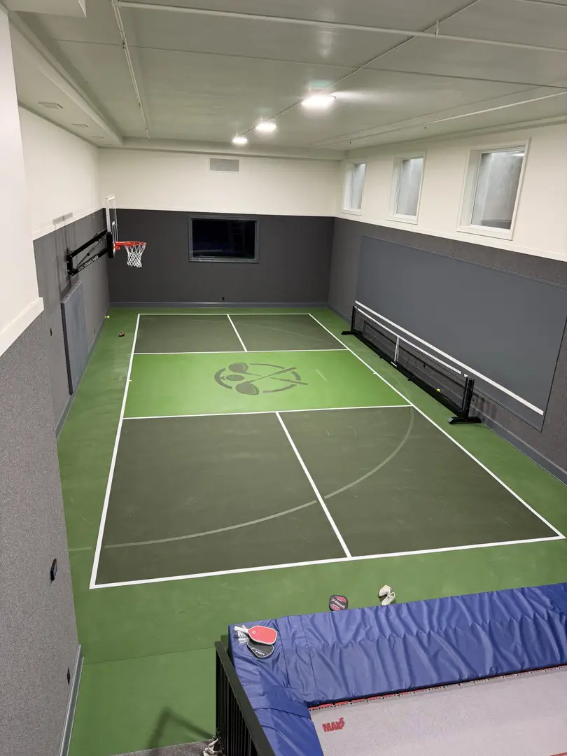 Indoor multi-sport court with basketball hoop and pickleball lines