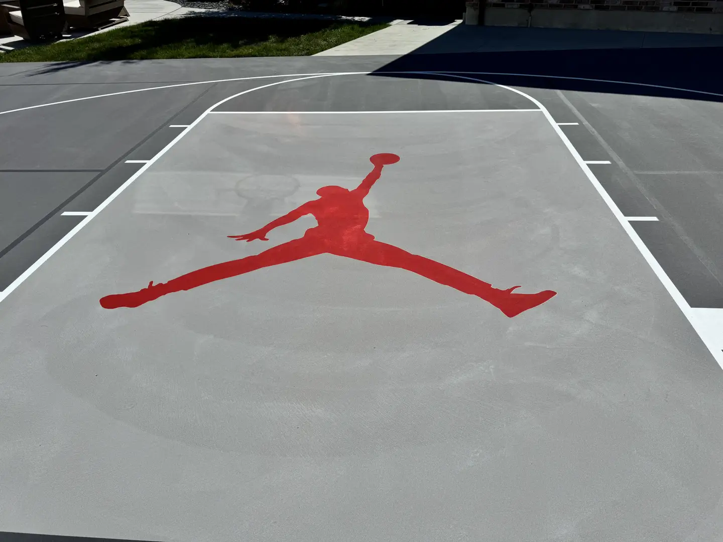 Red Jordan logo on a grey basketball court