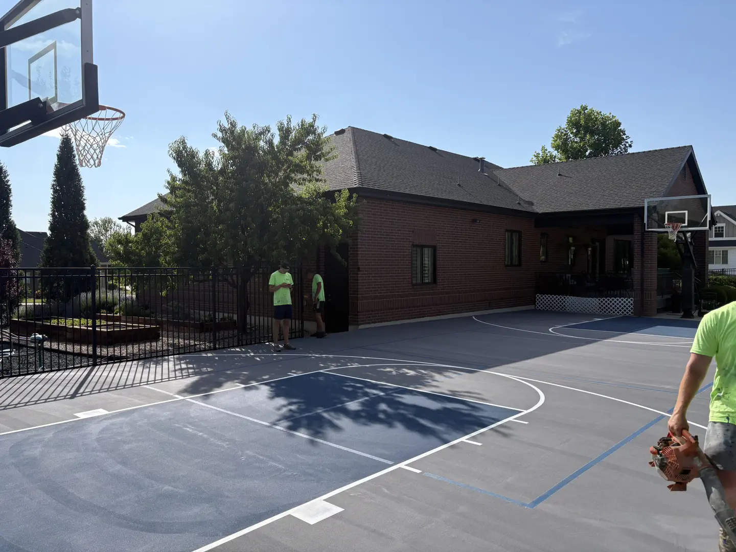 Newly painted basketball court with blue and gray sections.