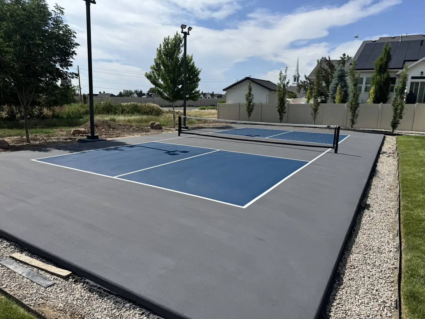Newly constructed outdoor pickleball court with blue playing surface and grey surround.