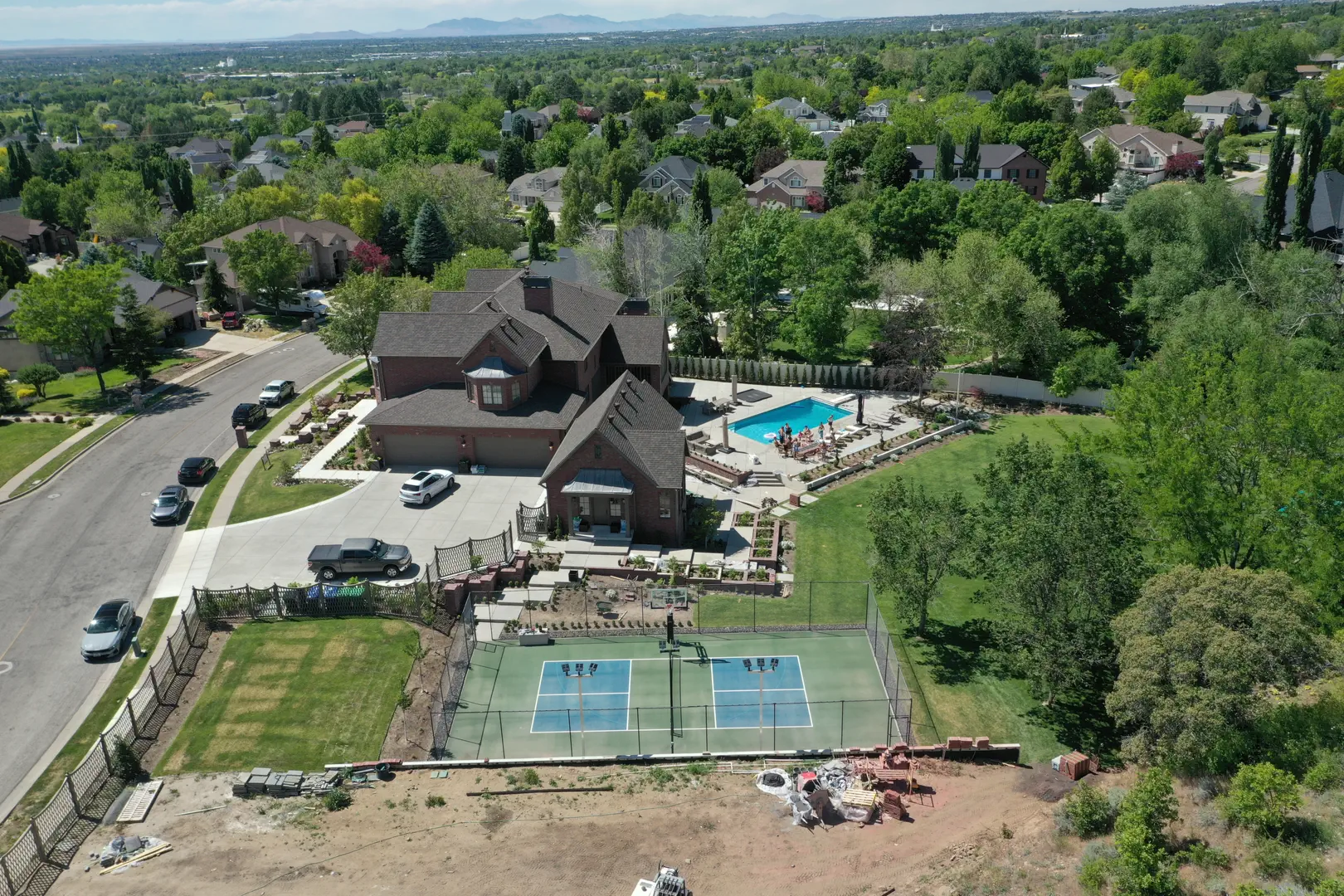 Aerial view of a luxury home with a pool and pickleball court.