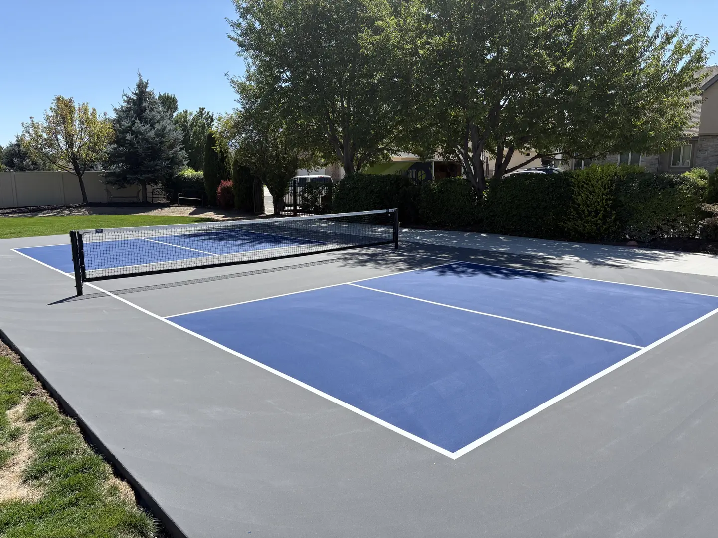Newly painted blue and gray pickleball court with net