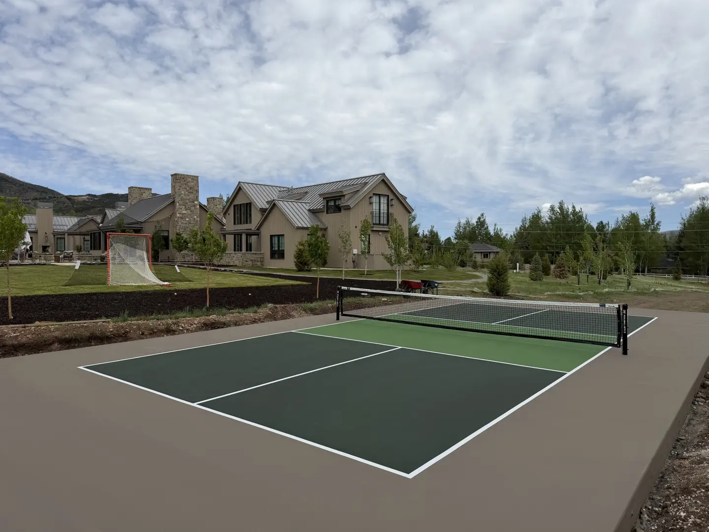 New pickleball court with a modern home in the background.