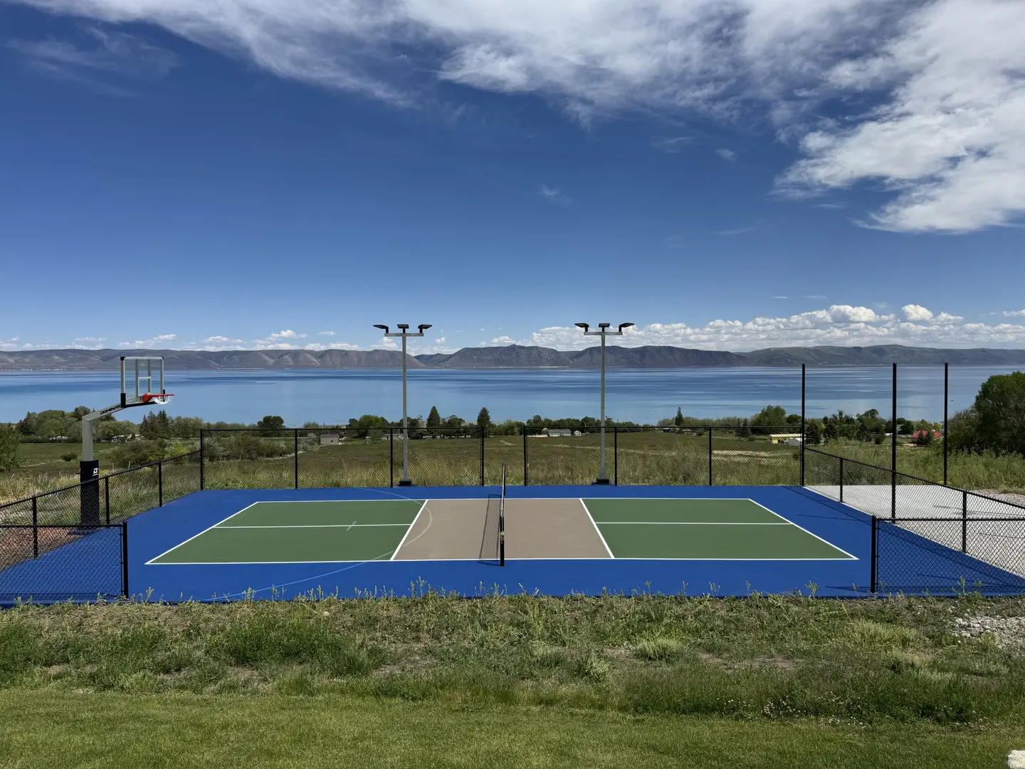 Multi-sport court with basketball hoop overlooking a lake