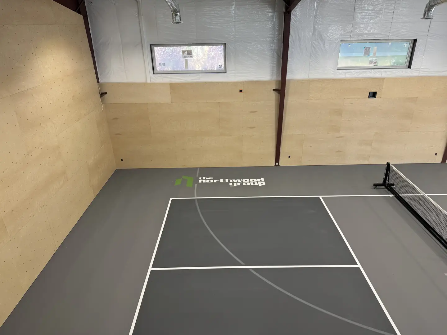 Indoor pickleball court with The Northwood Group logo