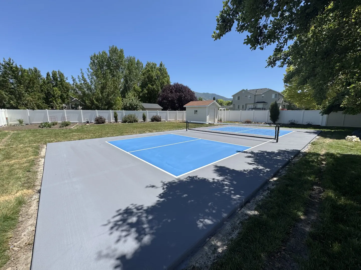 Newly painted blue pickleball court with gray surrounding area.