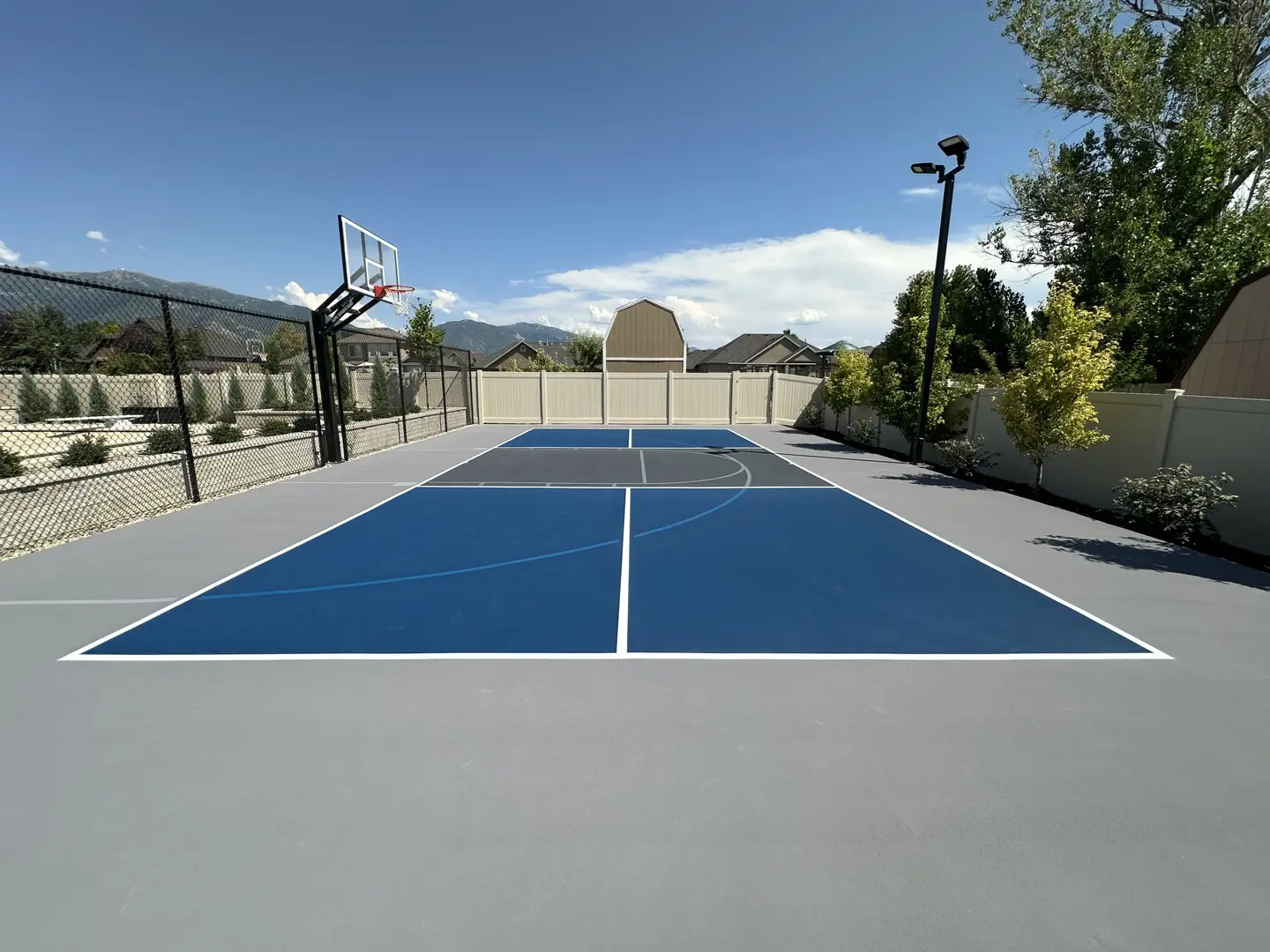 Modern blue and gray multi-sport court with basketball hoop