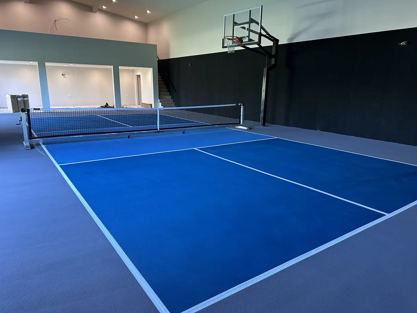 Indoor pickleball court with basketball hoop
