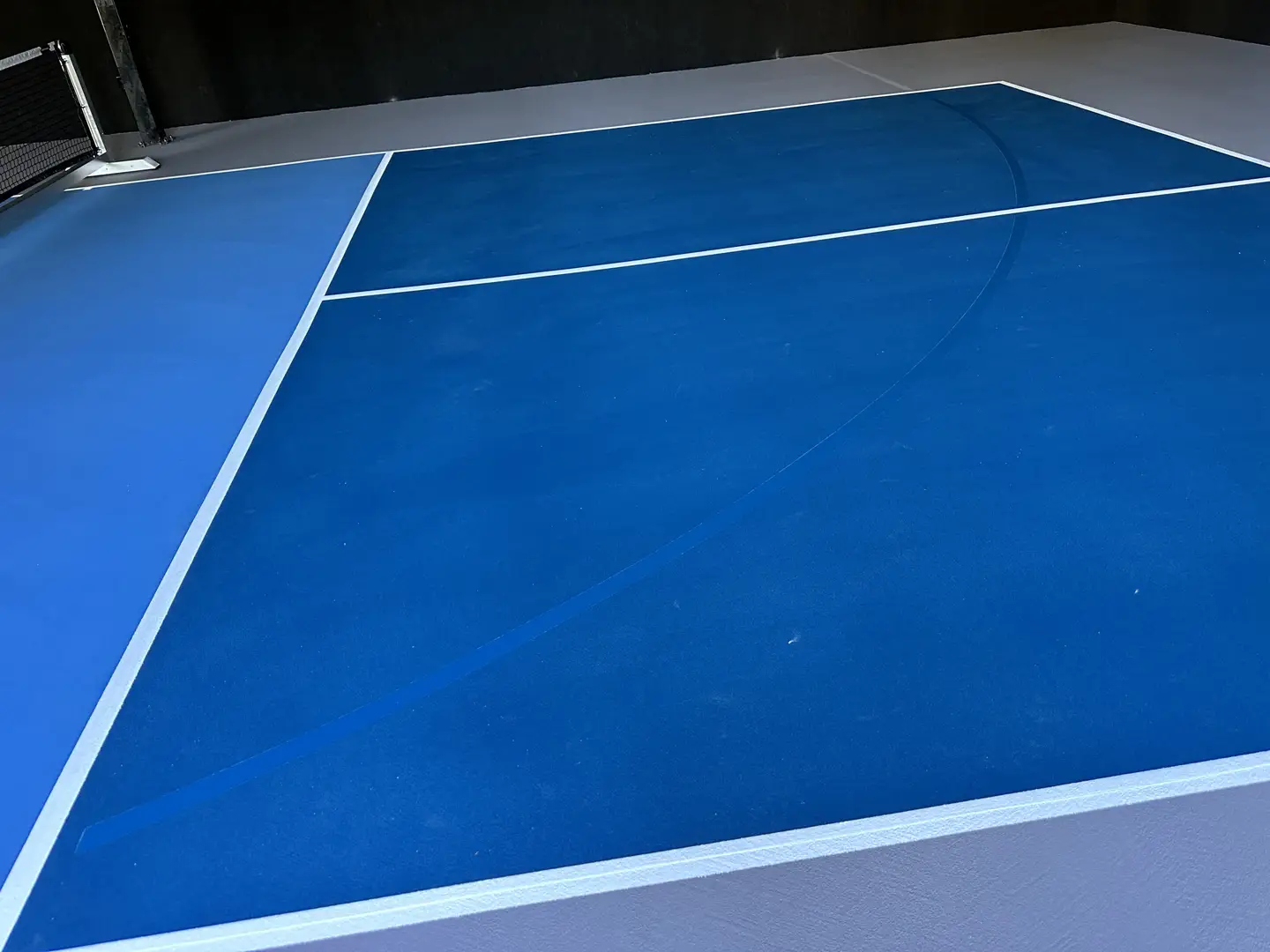 Blue pickleball court with white lines
