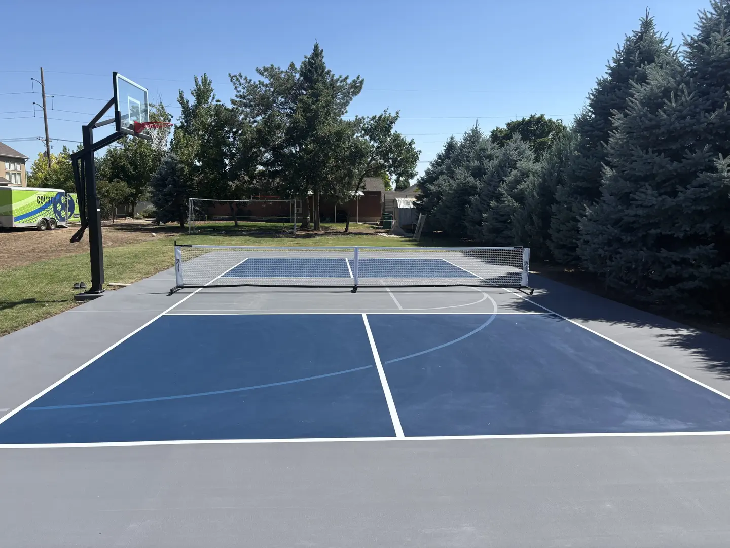 New pickleball court with basketball hoop and volleyball net
