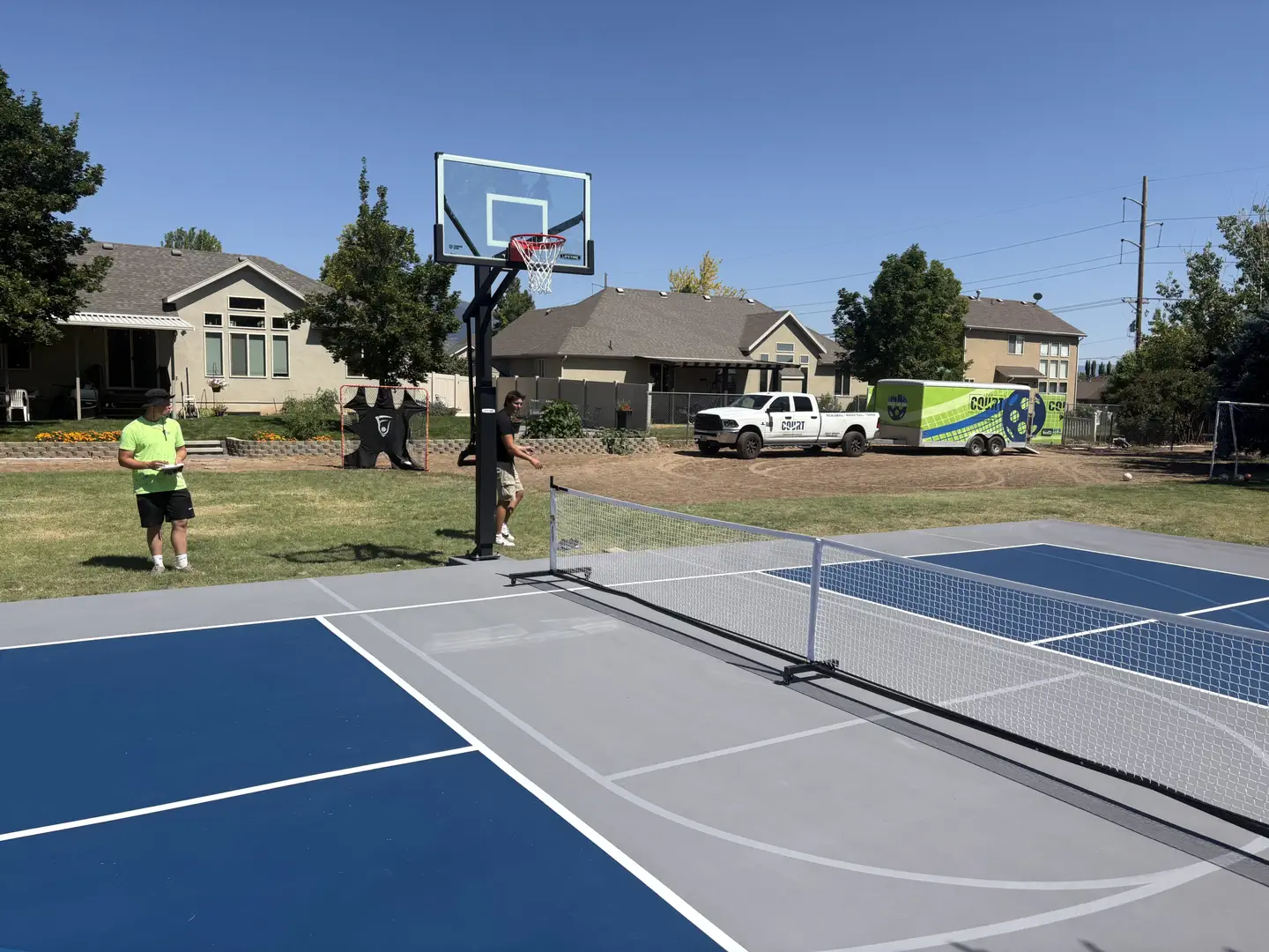 Backyard court with pickleball and basketball setup