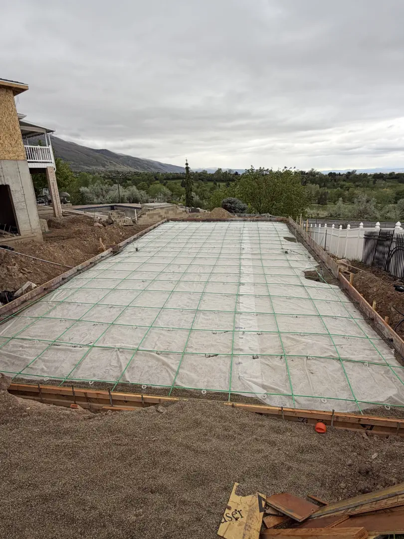 Concrete foundation preparation with rebar grid and vapor barrier