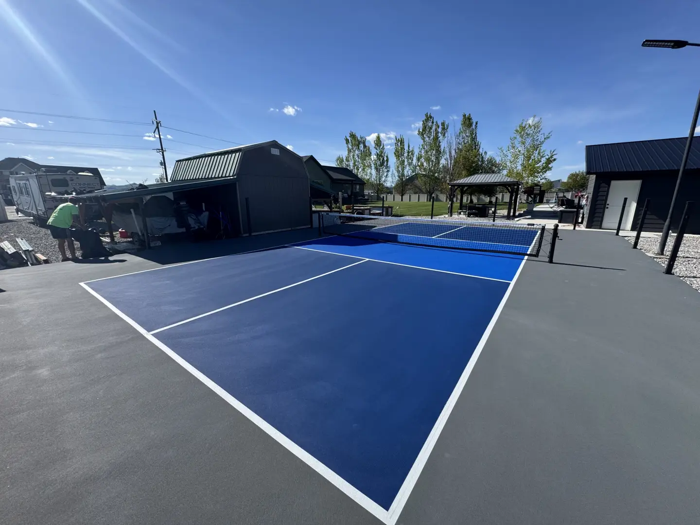 New blue pickleball court with white lines and net.