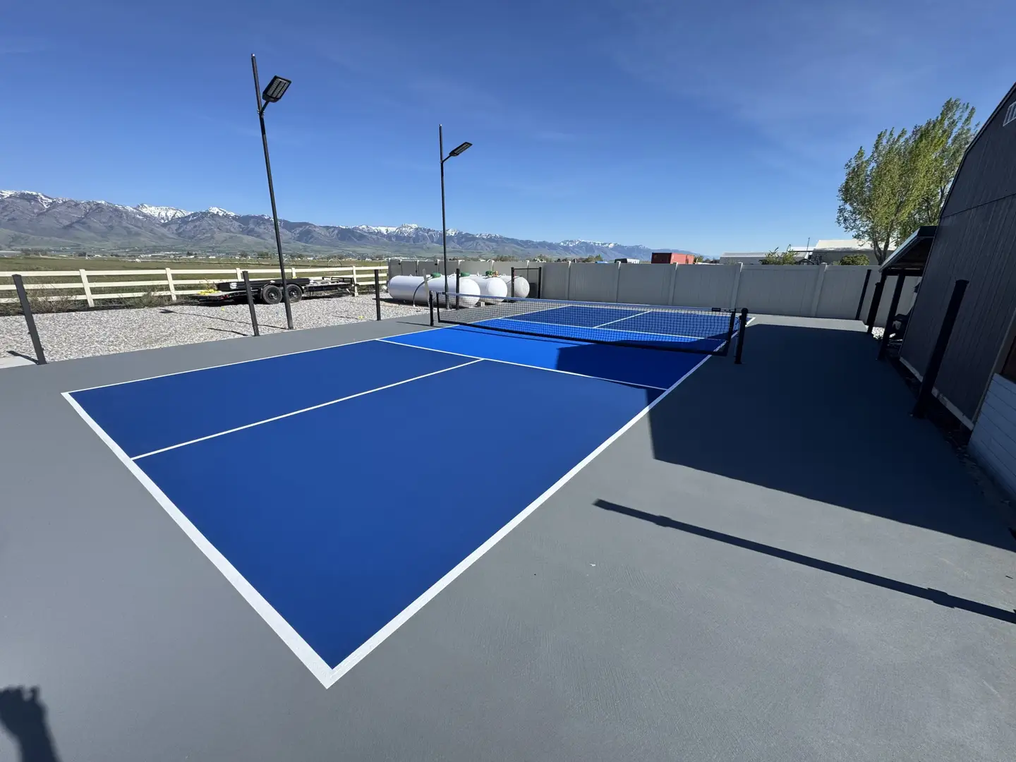 Bright blue pickleball court with mountain backdrop