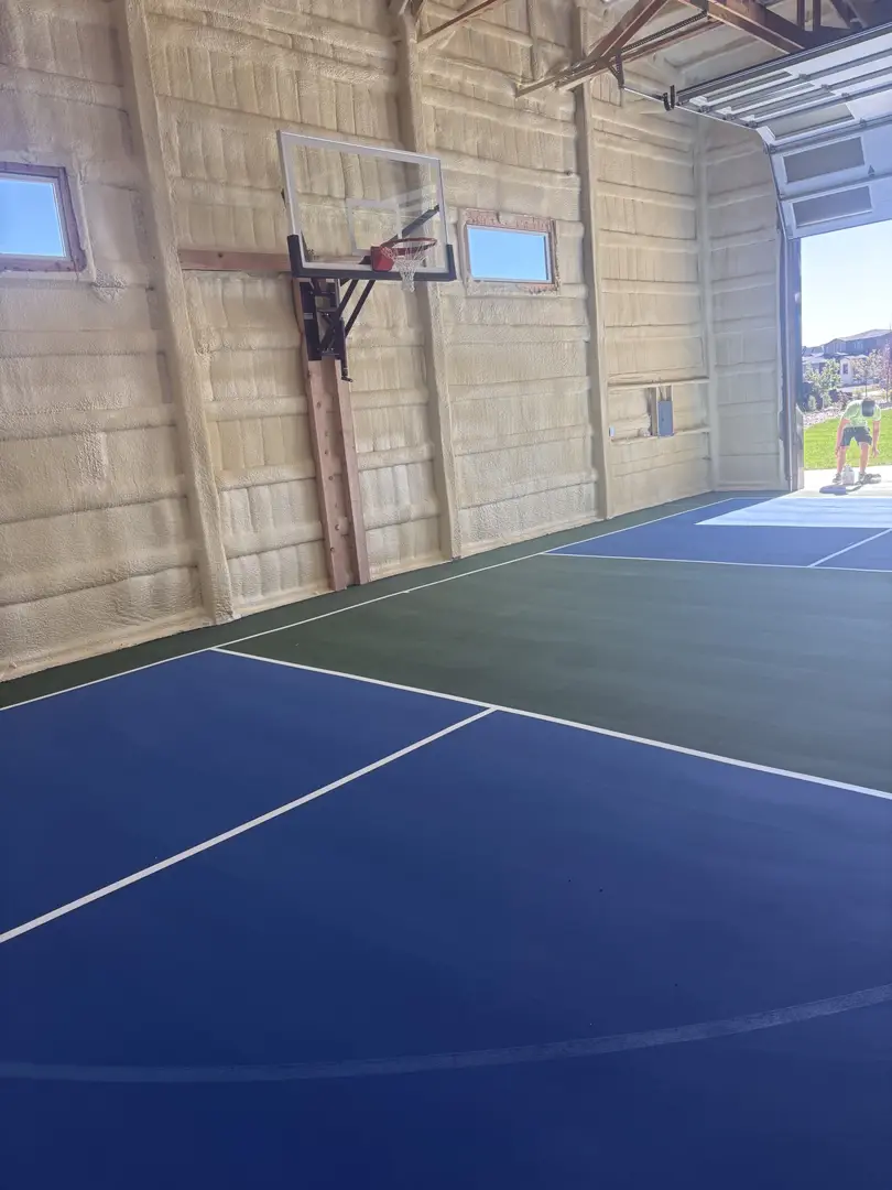 Indoor basketball court with blue and green playing surface.