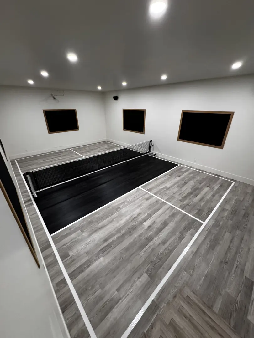 Indoor pickleball court with wood-look flooring and net