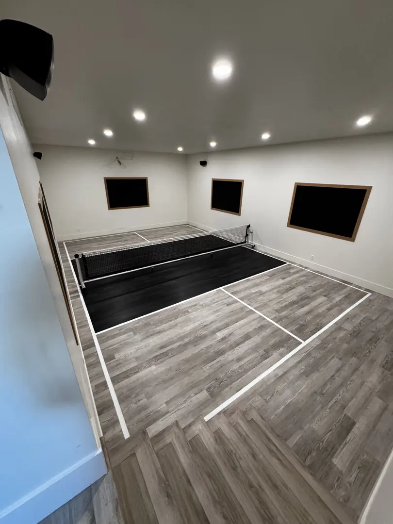 Indoor pickleball court with wood-look flooring and net