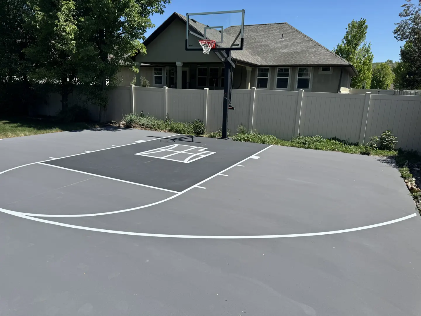 Newly painted basketball court with a modern grey surface and white lines.