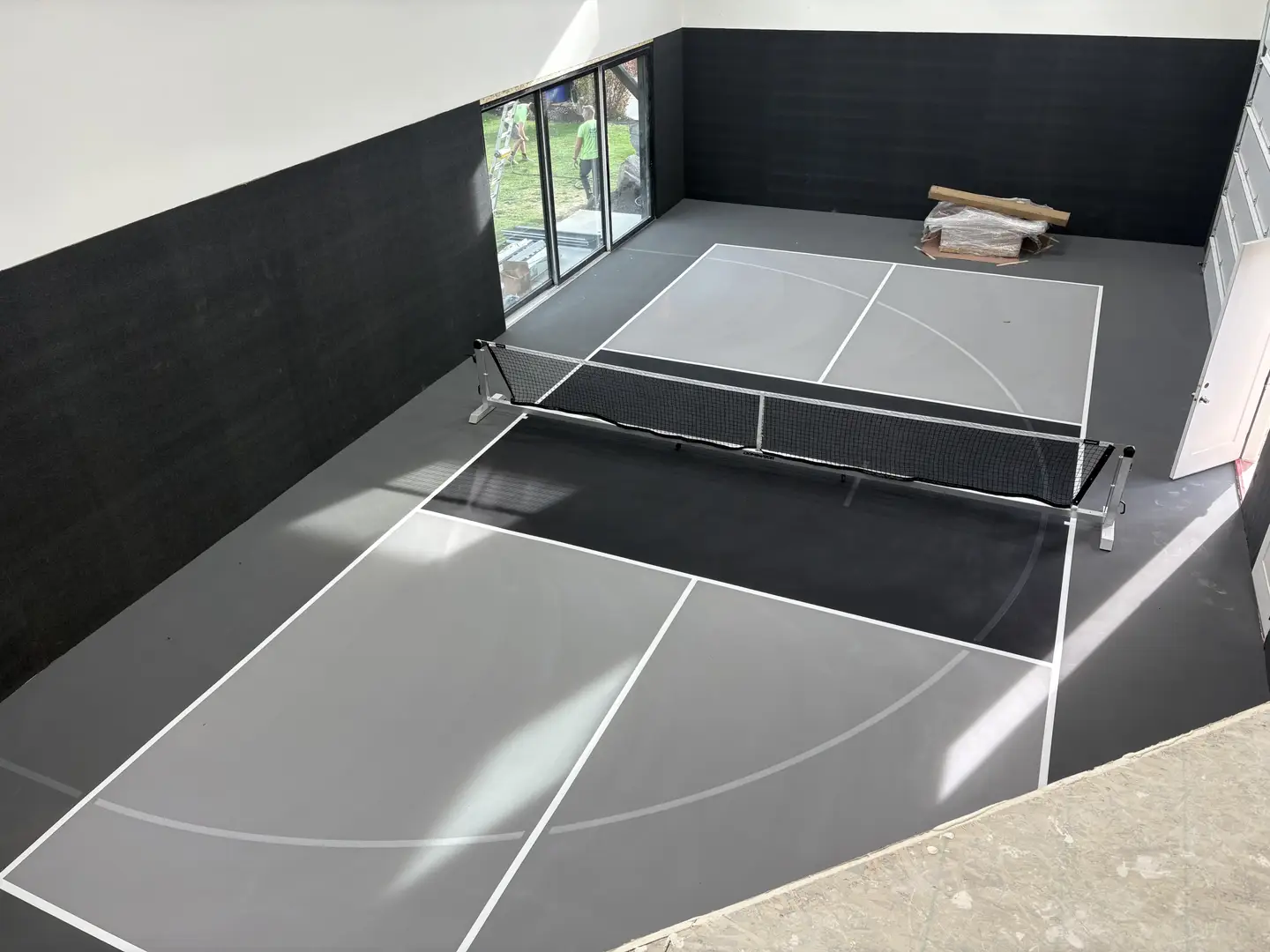 Newly painted indoor pickleball court with a net.