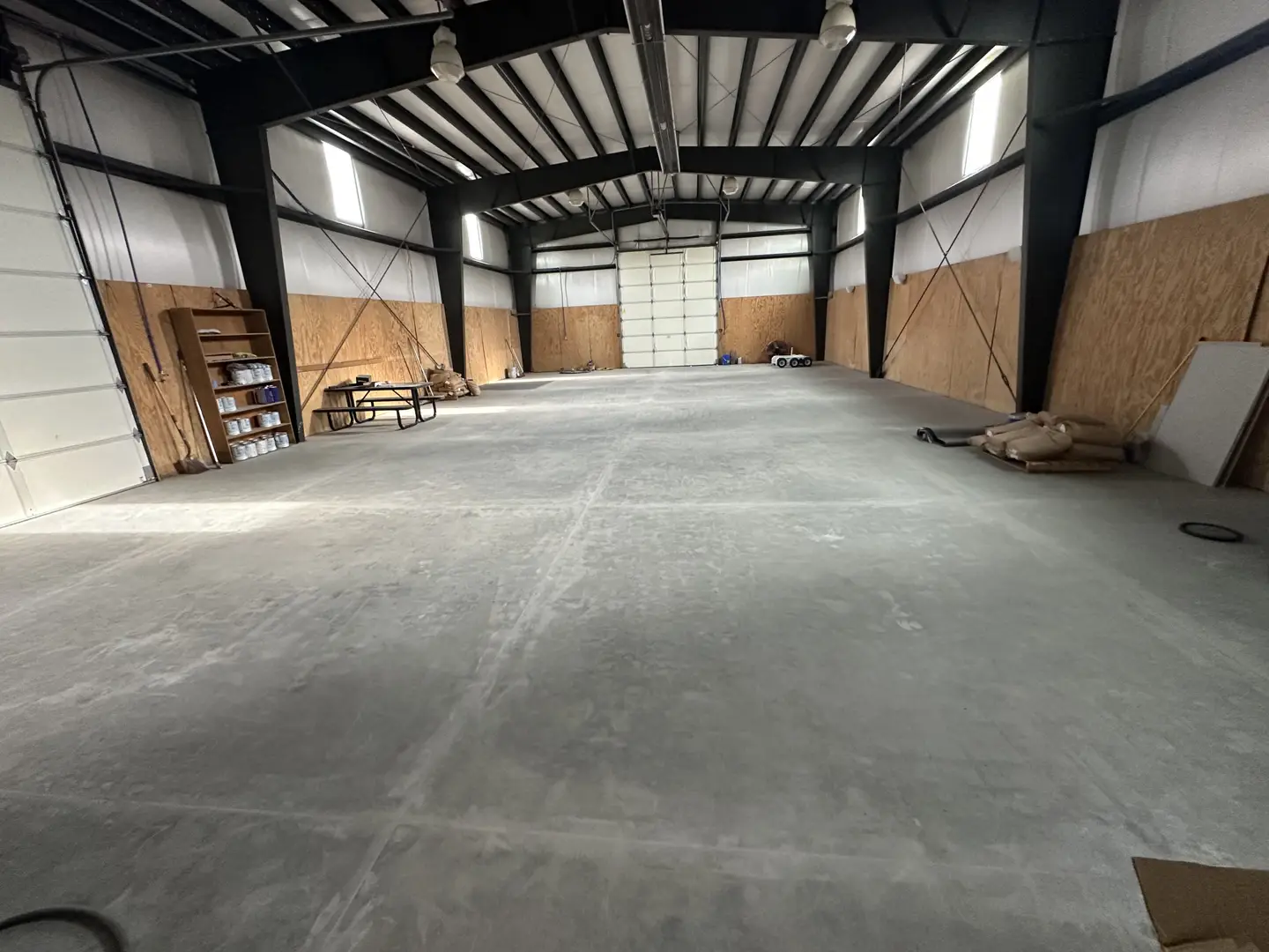 Spacious industrial warehouse interior with concrete floor and metal beams.