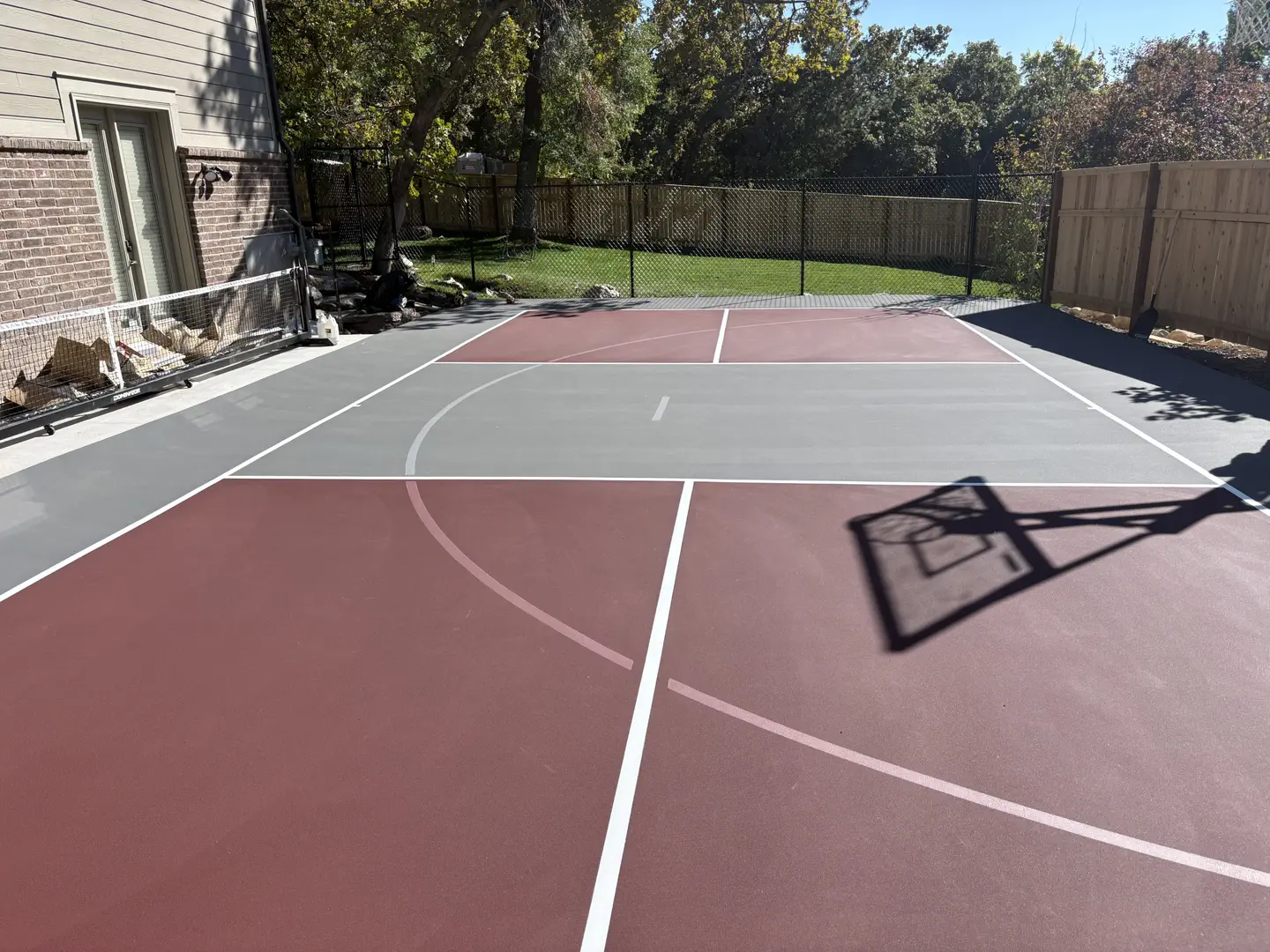 Newly painted multi-sport court with basketball hoop shadow
