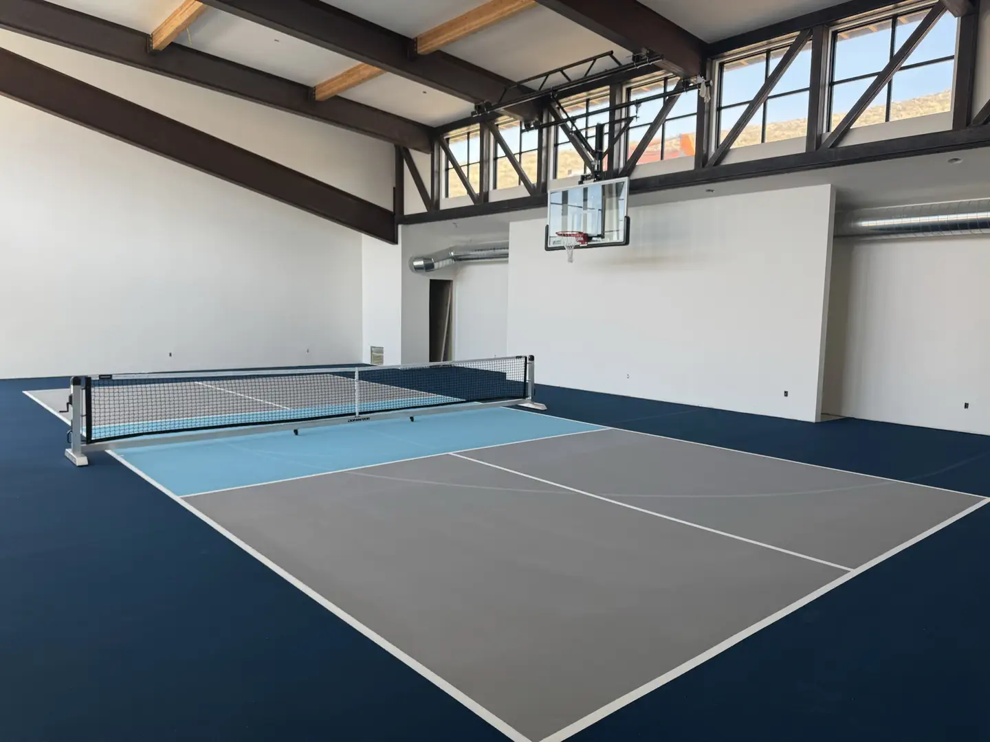 Indoor pickleball court with basketball hoop