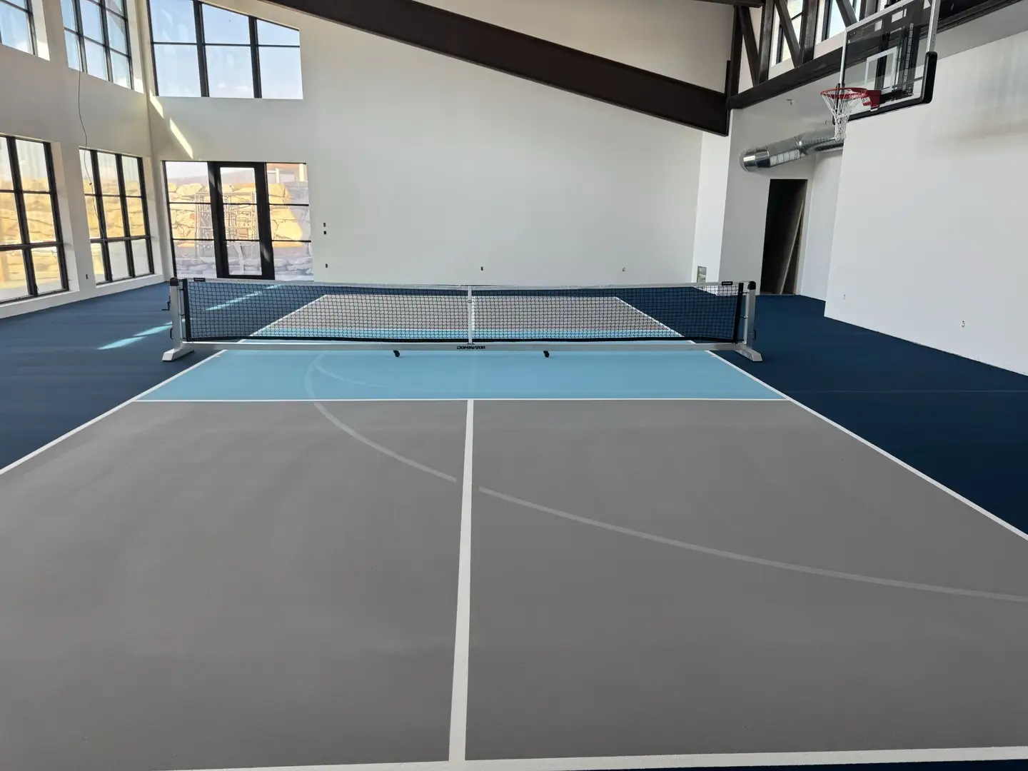 Indoor pickleball court with basketball hoop