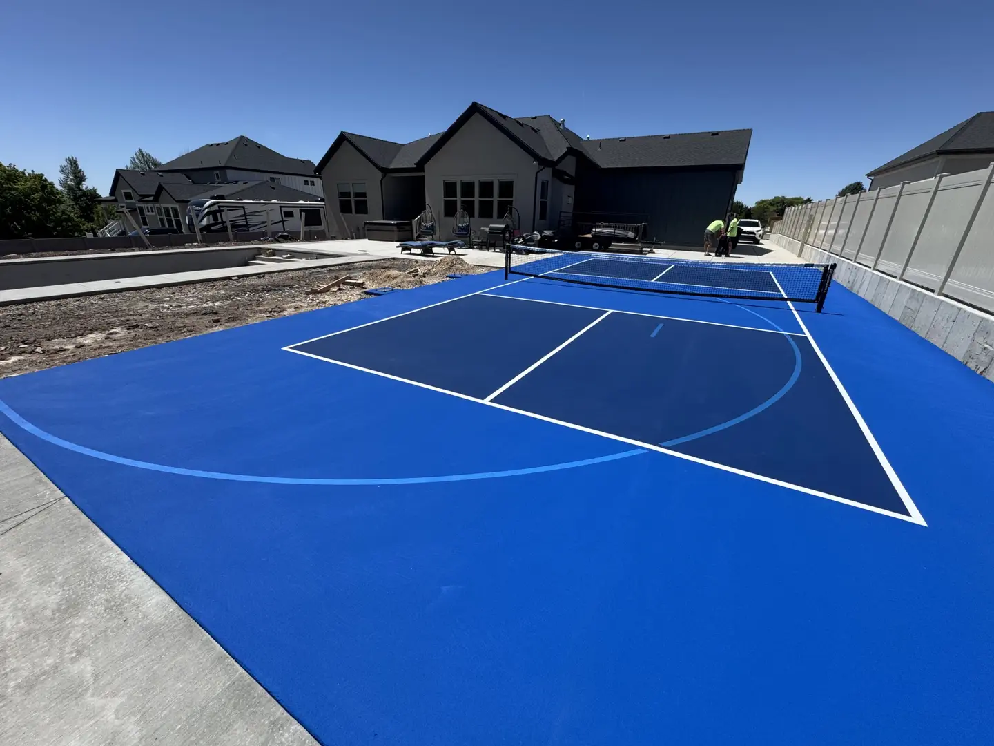 Vibrant blue pickleball court with white lines, ready for play.