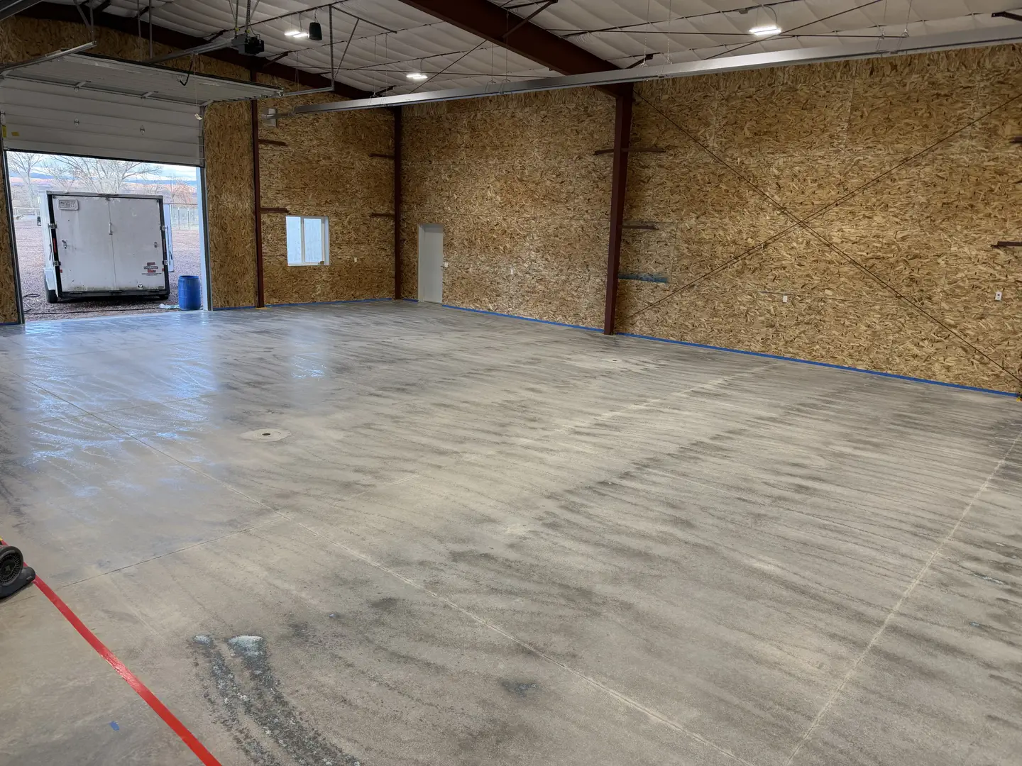 Interior of a new commercial garage with concrete floor and OSB walls.