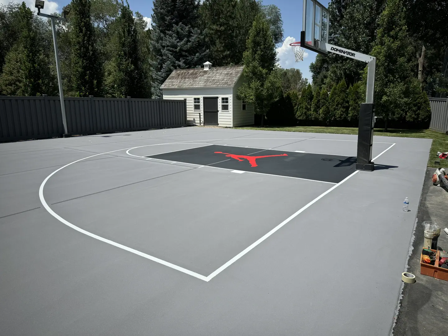 Newly painted basketball court with Jordan logo and hoop.