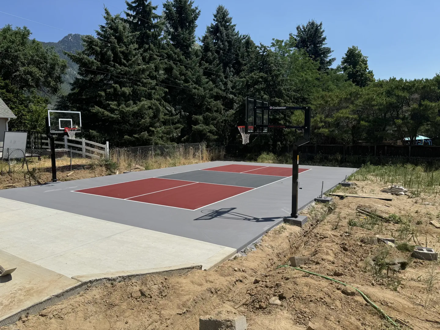 Newly installed basketball court with red and gray sections and Goalsetter hoops.