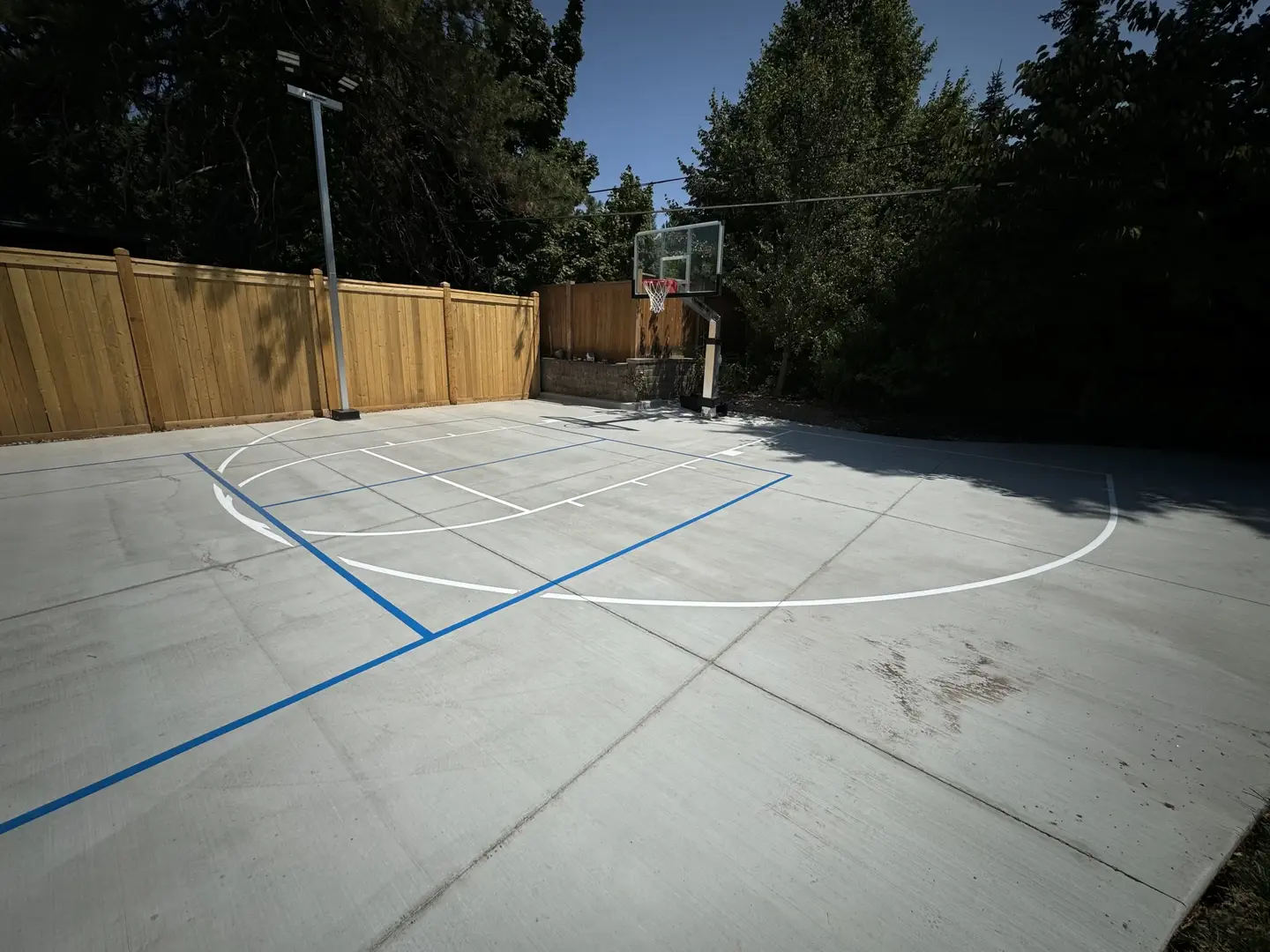 New backyard basketball court with blue and white lines
