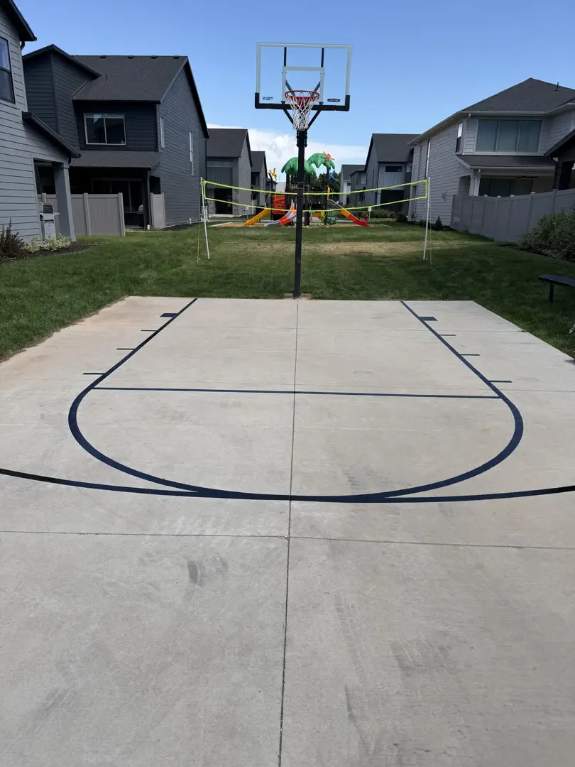 Backyard basketball court with hoop and volleyball net.