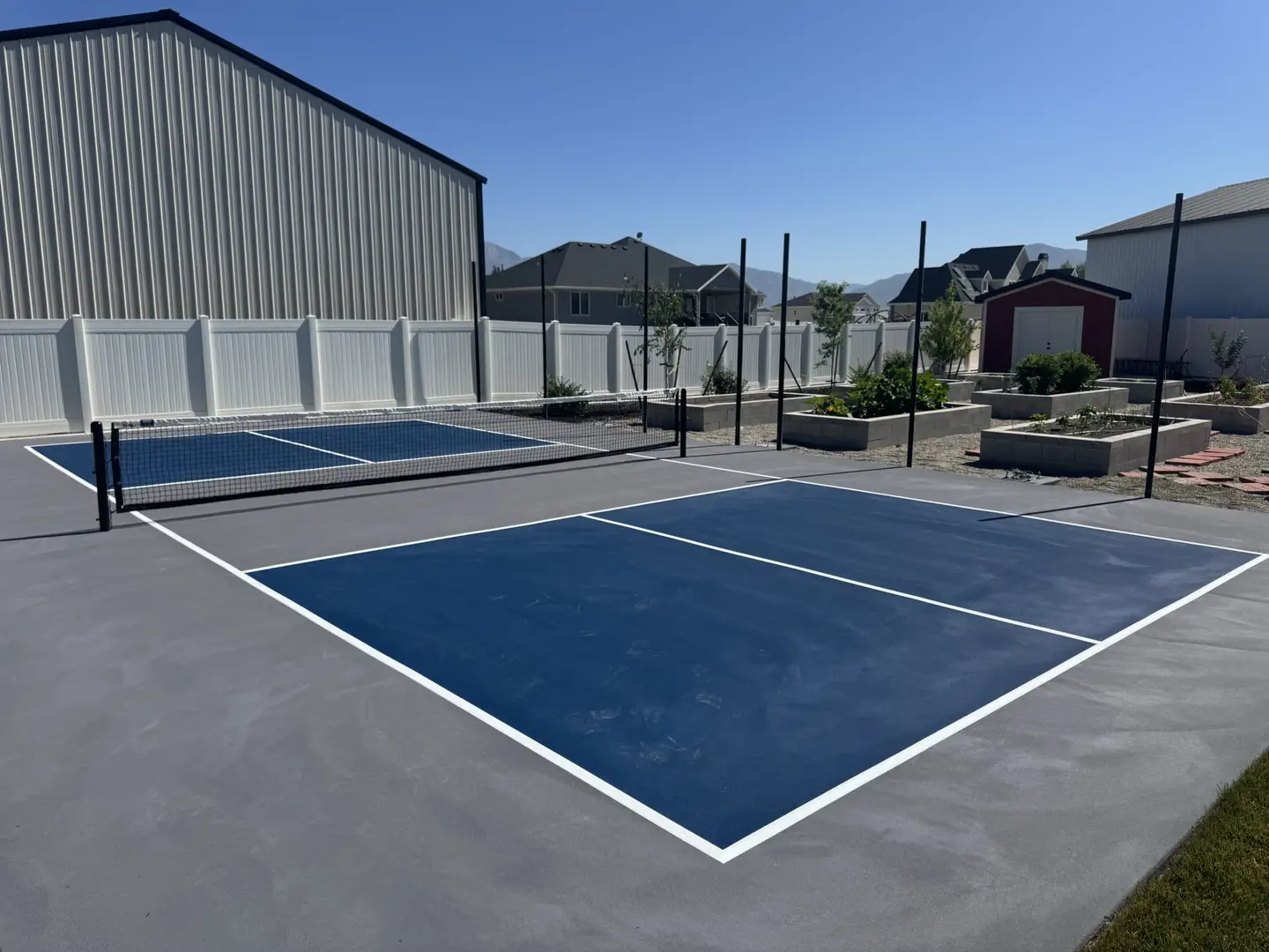 New blue and gray pickleball court with a white net.