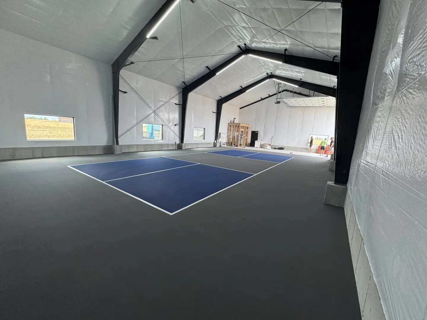 Indoor pickleball court with blue and gray playing surface